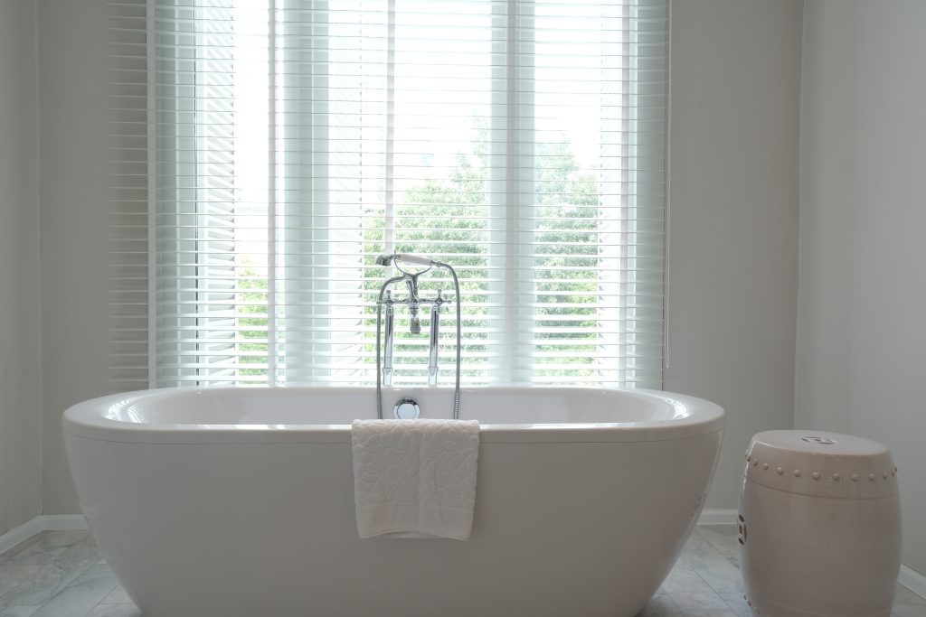 luxurious bathroom with a freestanding bathtub, a towel, and a stool